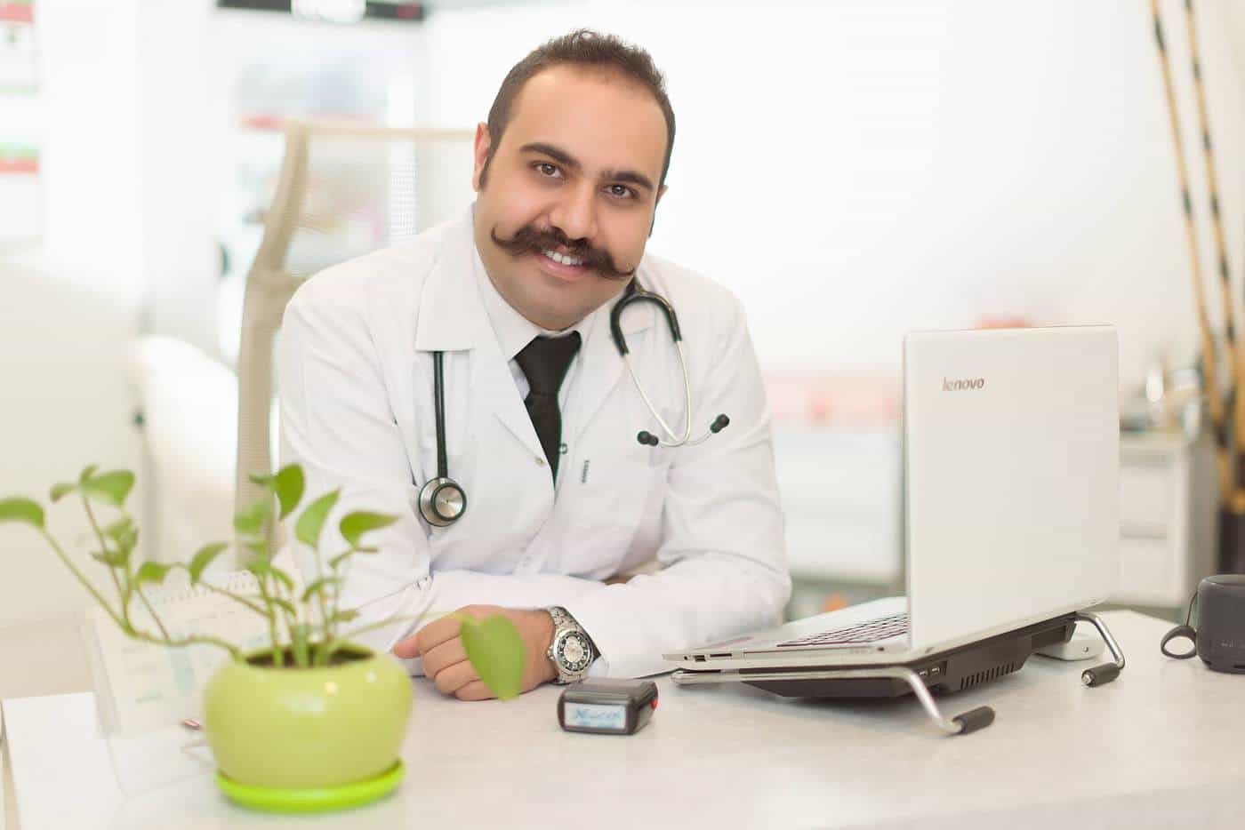 A doctor seated at a desk in a clinical office